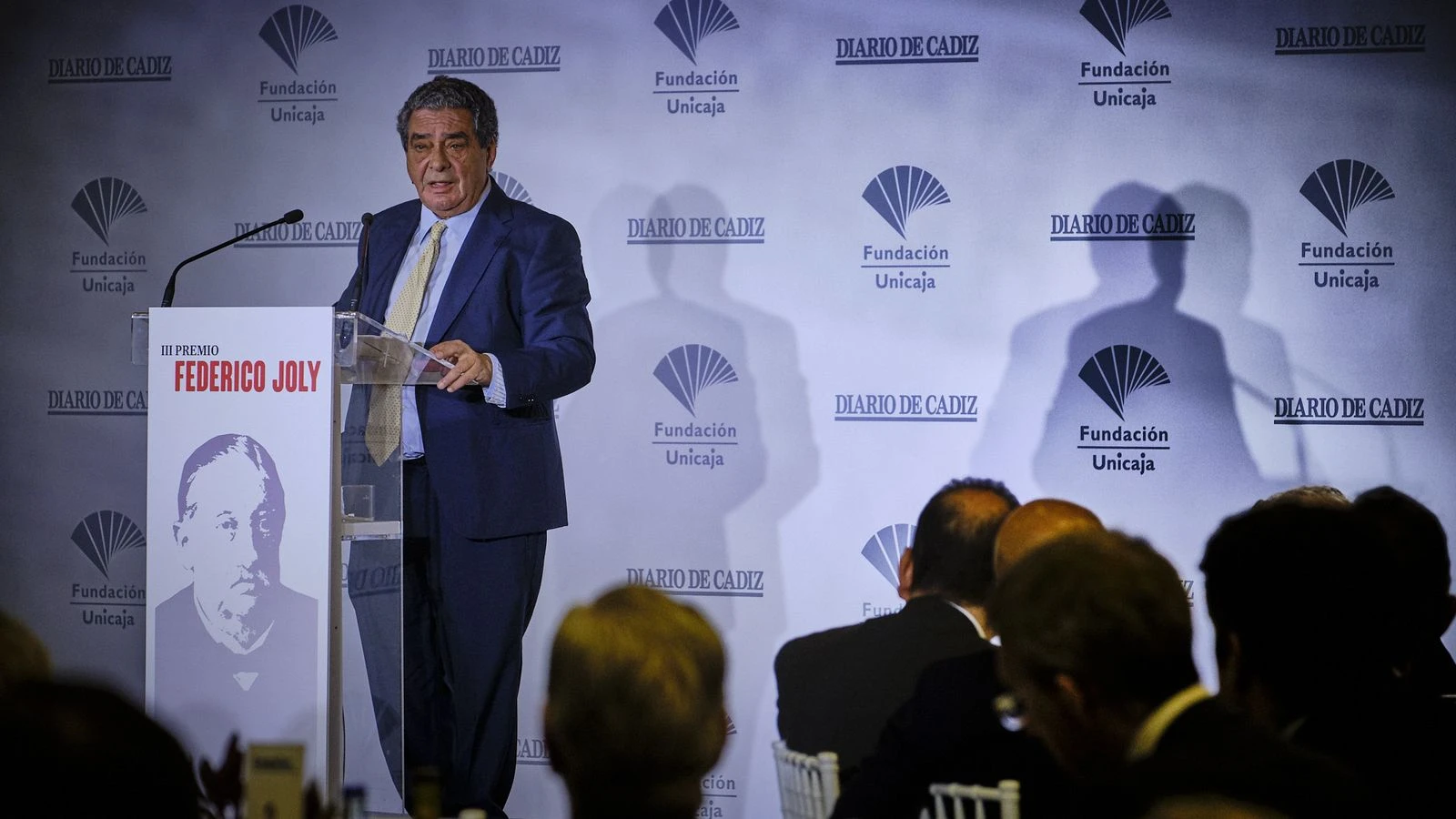 El periodista Augusto Delkáder hablando desde un atril durante la entrega de un premio.
