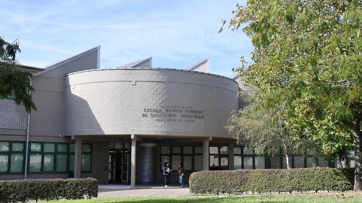Fachada exterior de la Escuela Técnica Superior de Ingeniería Industrial de la Universidad de Vigo, con un edificio de estructura semicircular y ventanales verdes.