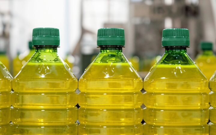 Botellas de aceite de oliva envasadas en una línea de producción industrial.