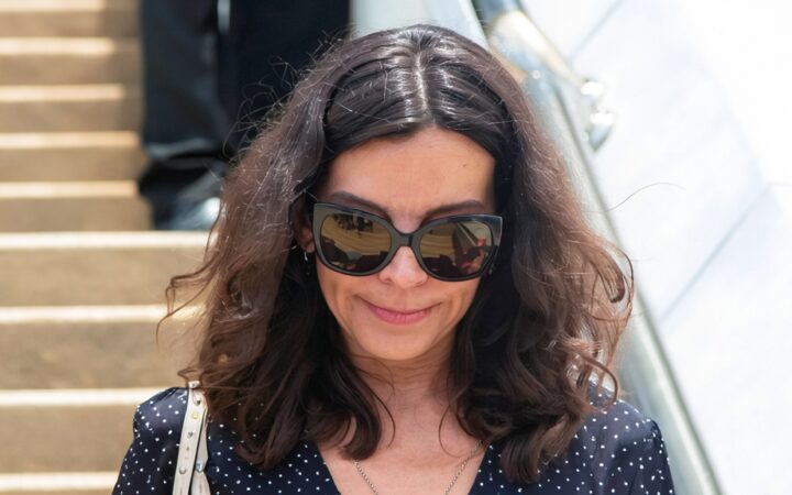 Silvia Bronchalo con gafas de sol oscuras y blusa de lunares caminando por unas escaleras exteriores.